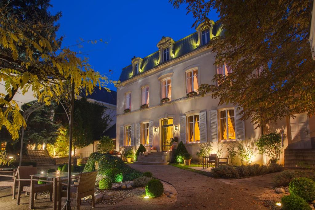 ein großes weißes Gebäude mit Lichtern in der Nacht in der Unterkunft Hostellerie Cèdre & Spa Beaune in Beaune