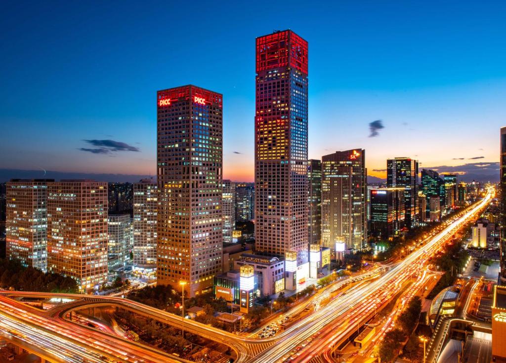 un perfil urbano con edificios altos y tráfico por la noche en Park Hyatt Beijing, en Beijing