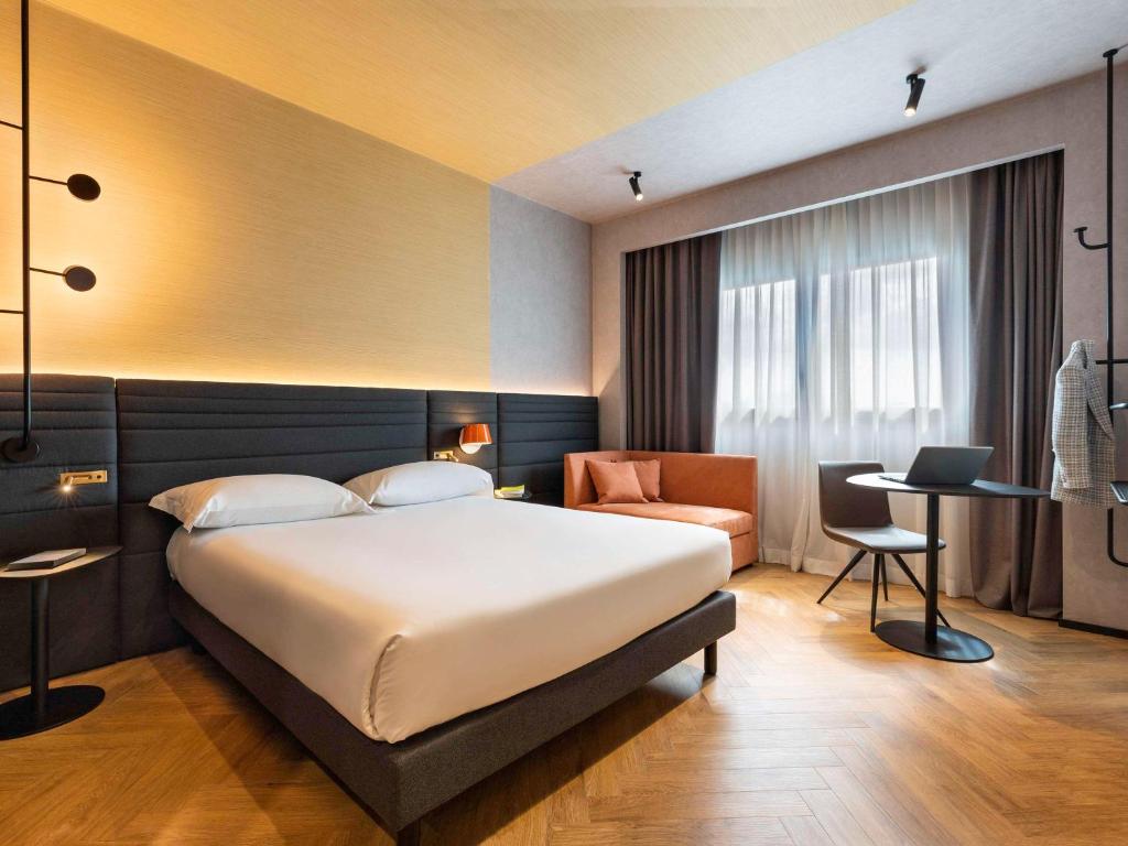 カゼルタにあるNovotel Caserta Sudのベッドルーム1室(ベッド1台、デスク、椅子付)