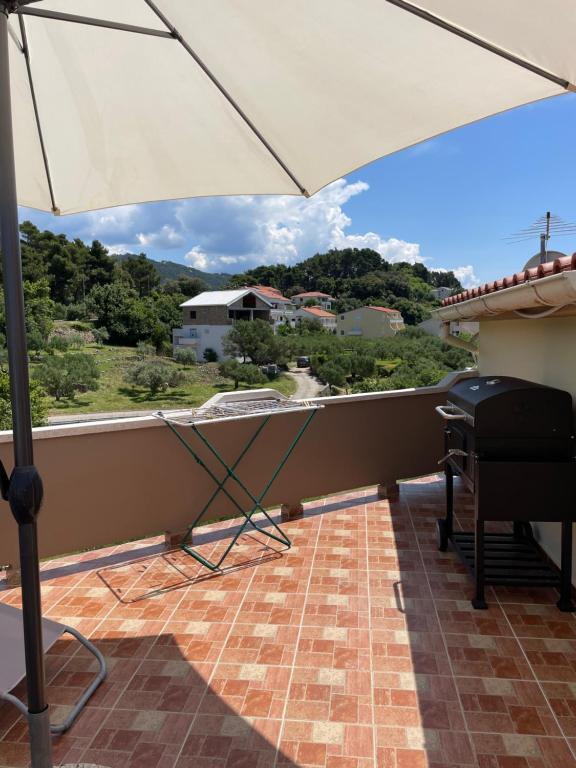 a white umbrella on a balcony with a view at Penthouse Damjan in Rab
