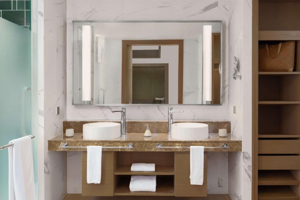 a bathroom with two sinks and a large mirror at Banyan Tree Phuket in Bang Tao Beach