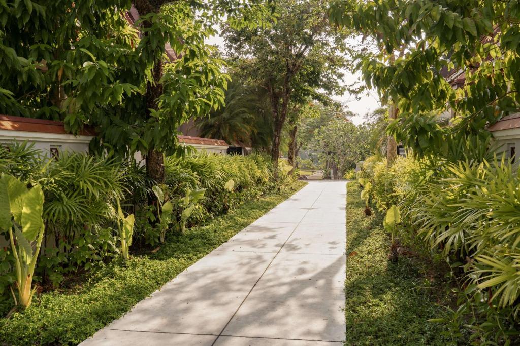 a sidewalk in front of a house with trees at Banyan Tree Phuket in Bang Tao Beach