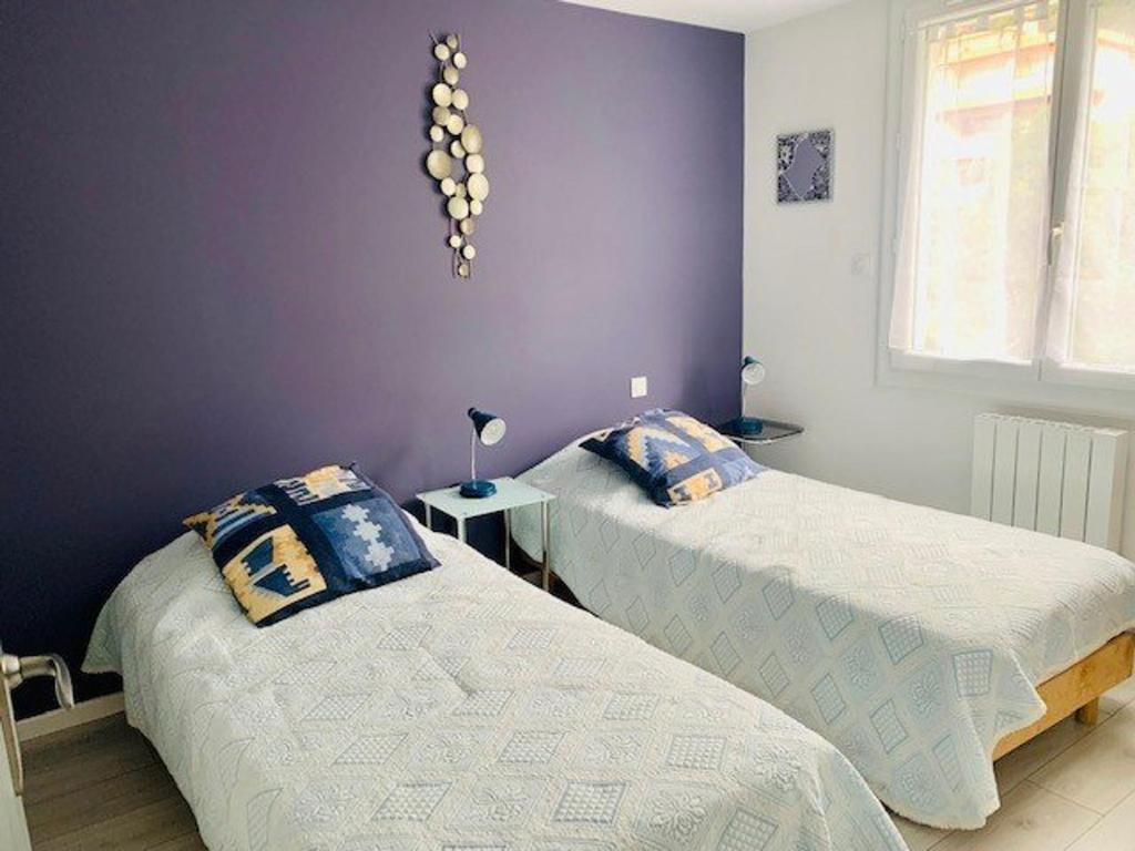 2 łóżka w pokoju z fioletowymi ścianami w obiekcie Charmant F3 climatisé avec balcon ensoleillé, proche centre et Thermes - Amélie-les-Bains - FR-1-703-80 w mieście Amélie-les-Bains-Palalda
