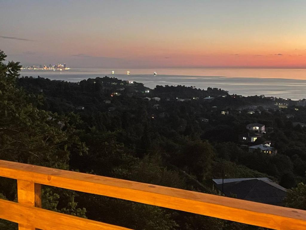 een houten bank met uitzicht op de oceaan bij SUNSET BUKNARI in Buknari