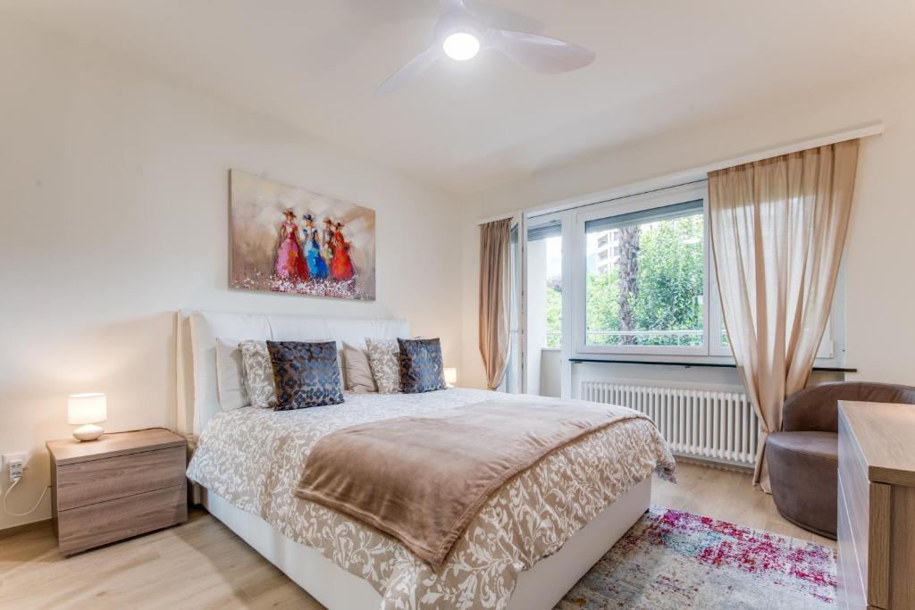 a bedroom with a bed and a window at RELAX Camelia Apartment in Locarno