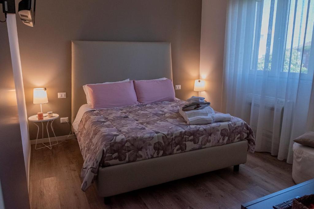 sypialnia z łóżkiem z różowymi poduszkami i 2 lampami w obiekcie La Dimora Del Bue w mieście Matera