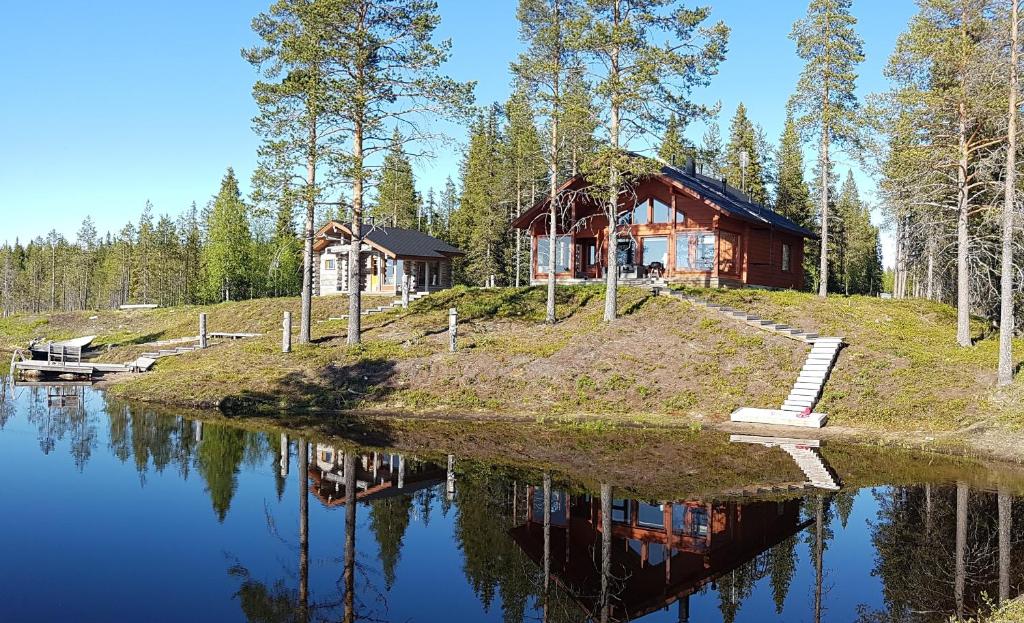 a log cabin on a hill next to a lake at Villa Kanger in Kuusamo