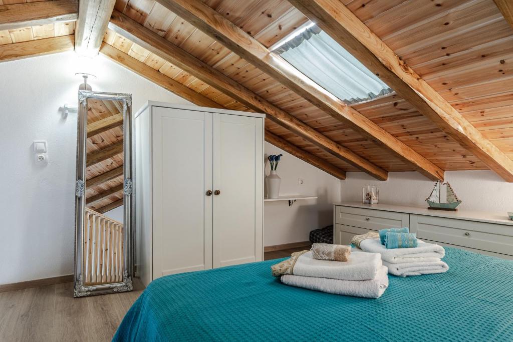 una camera da letto con un letto verde e asciugamani di Dream on a wave a Città di Skiathos