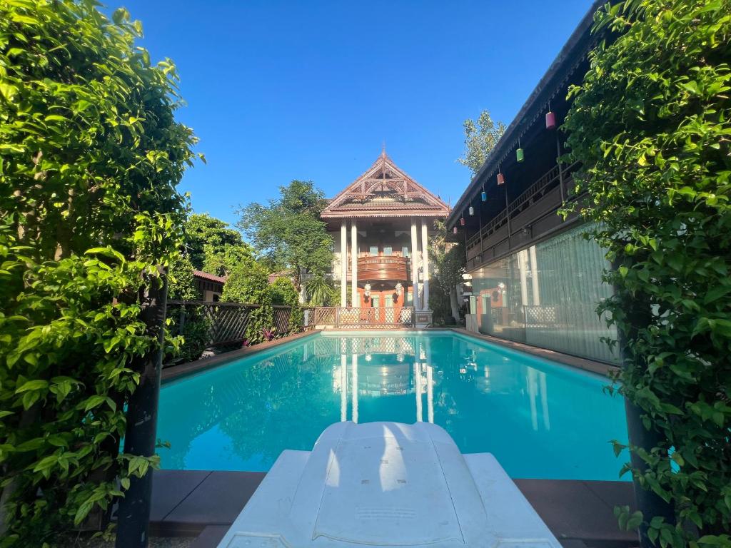 a swimming pool in front of a house with a gazebo at Pha Thai House in Chiang Mai