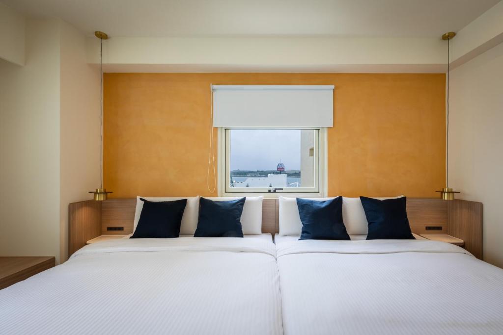 a bedroom with a large bed with a window at Hotel Ever Spring - Penghu in Magong