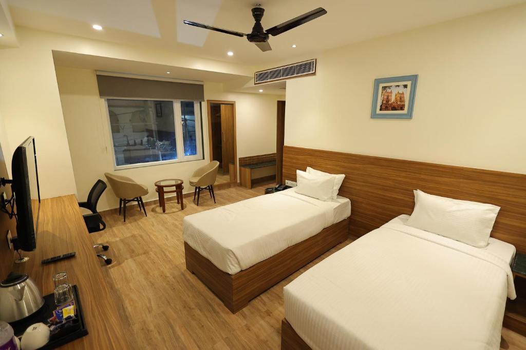 pokój hotelowy z 2 łóżkami i telewizorem w obiekcie Hotel Sharda Residency w mieście Patna