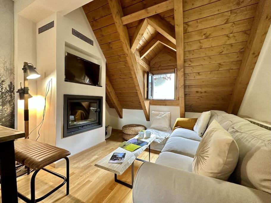 a living room with a white couch and a fireplace at La Glera. En el centro de Sallent de Gállego in Sallent de Gállego