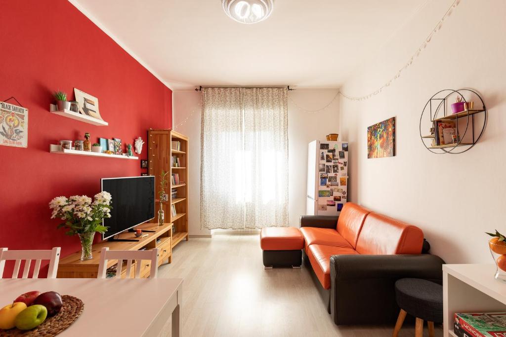 コルマーノにあるCosy flatの赤い壁のリビングルーム(ソファ付)