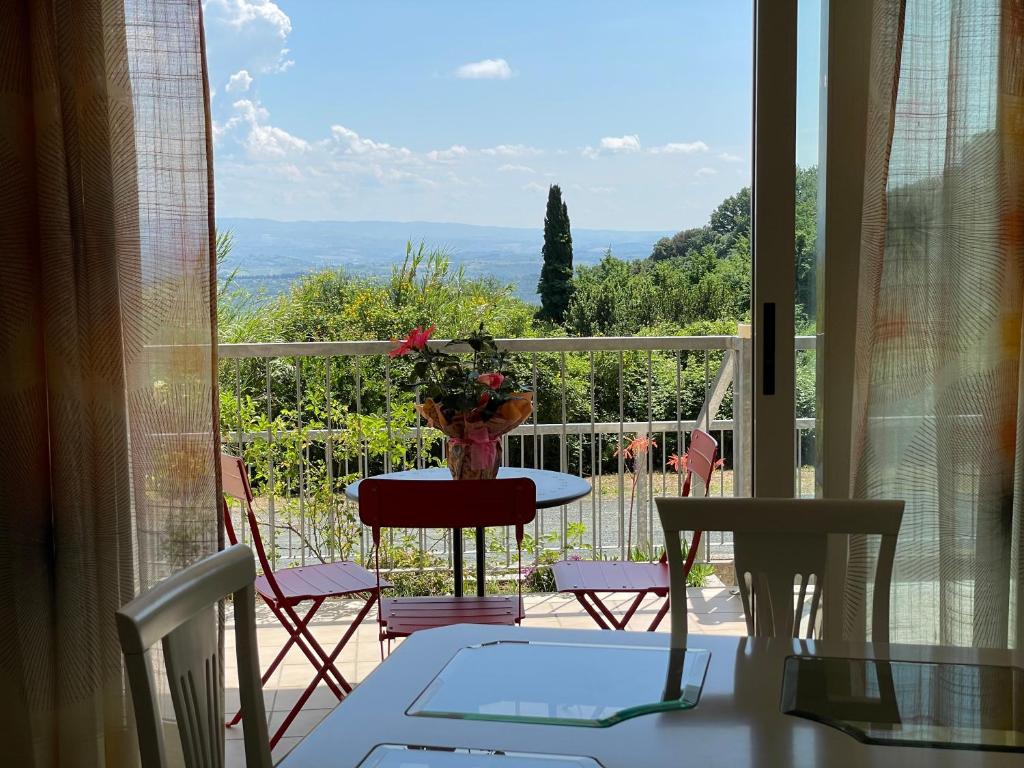 Habitación con vistas a un balcón con mesa y sillas. en A Casa Di Silvia, en Gambassi Terme
