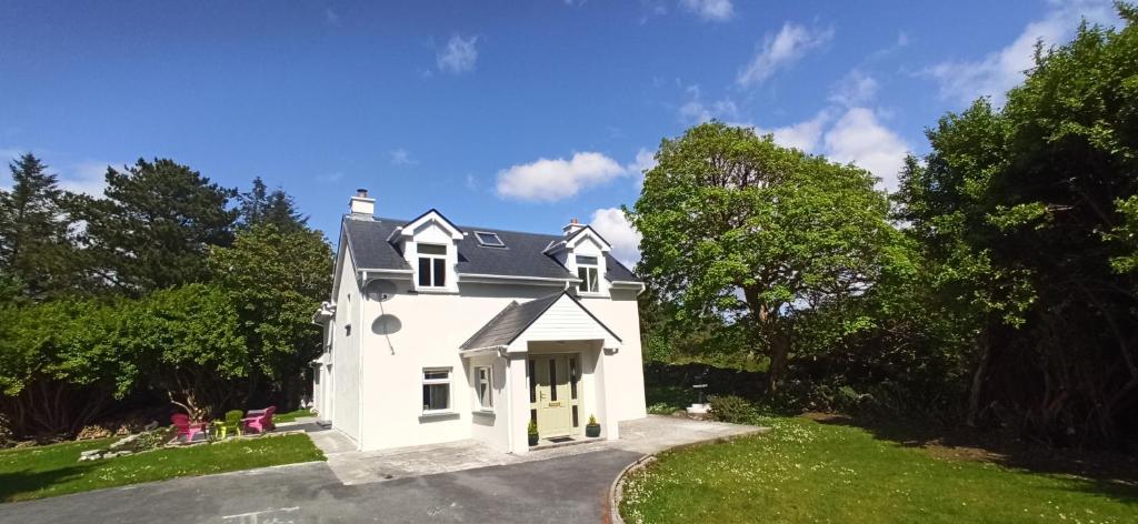 a white house with a driveway at Atlantic Way Cottage in Galway
