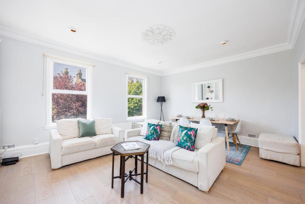 ein Wohnzimmer mit 2 weißen Sofas und einem Tisch in der Unterkunft WelcomeStay Colliers Wood Two Bed Apartment - Home Away from Home in London