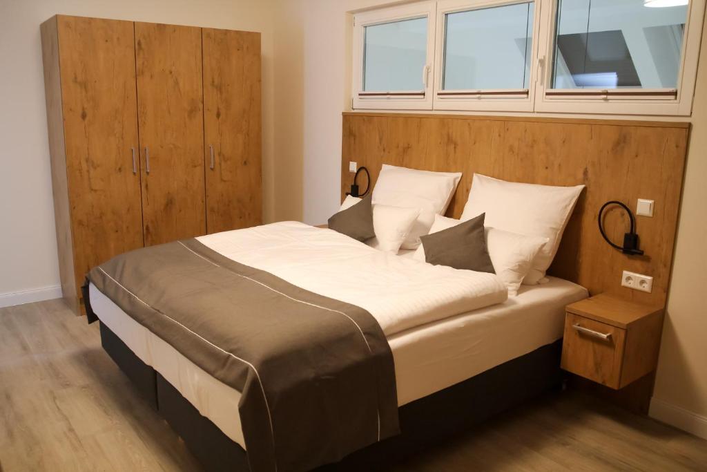a bedroom with a large bed with a wooden headboard at Ferienwohnung "Landhaus Buchenallee" in Bad Bentheim