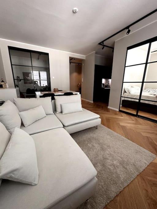 a living room with a white couch and two windows at Luxury City Center Suite in Helsinki