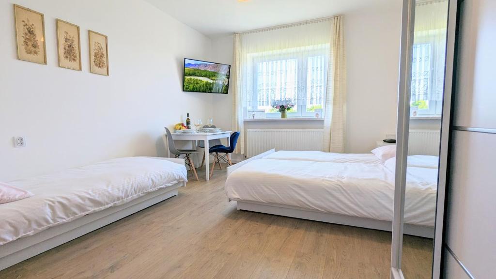 1 dormitorio con 2 camas y mesa. en Dom nad Jeziorem, en Szczedrzyk