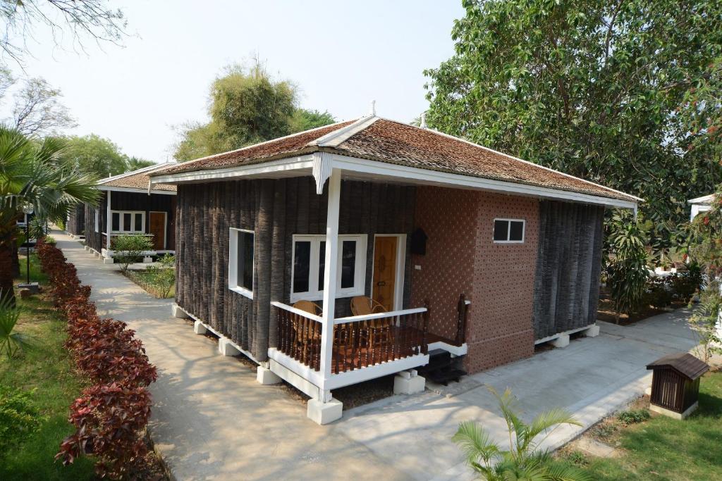 una pequeña casa de ladrillo rojo con porche en KMA Bagan Village Hotel, en Bagan