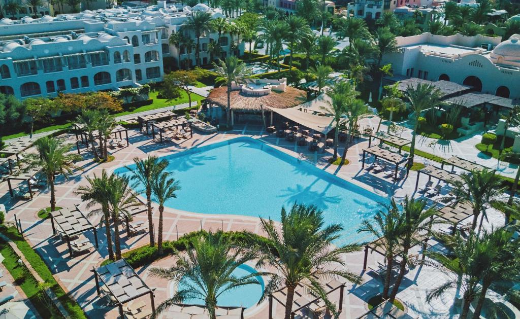 een luchtzicht op een zwembad van het resort met palmbomen bij Jaz Makadi Star & Spa in Hurghada