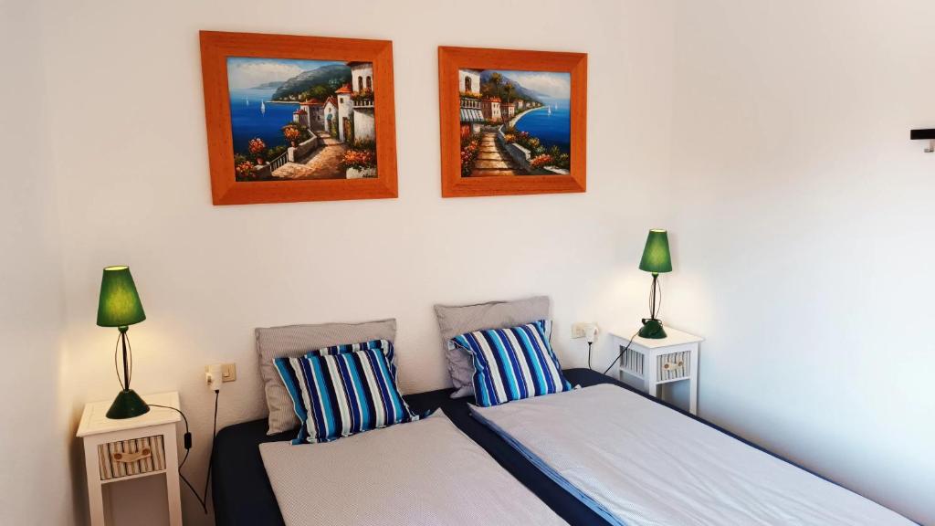 1 dormitorio con 2 camas y 2 lámparas en la pared en Santa Polita, en Santa Pola