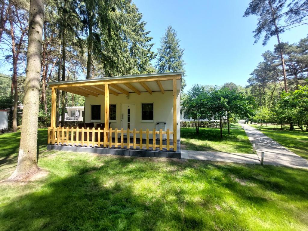 HeideseeにあるFerienbungalows am Wolziger Seeの木立公園内の小さな黄色い建物