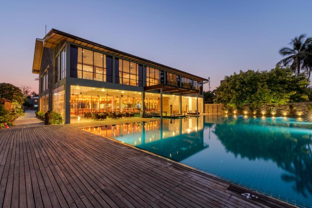 a house with a swimming pool in front of it at Regenta Arie Lagoon Negombo in Negombo