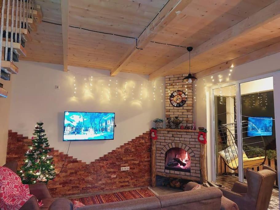 a living room with a fireplace and a tv at Happy days house in Shuakhevi