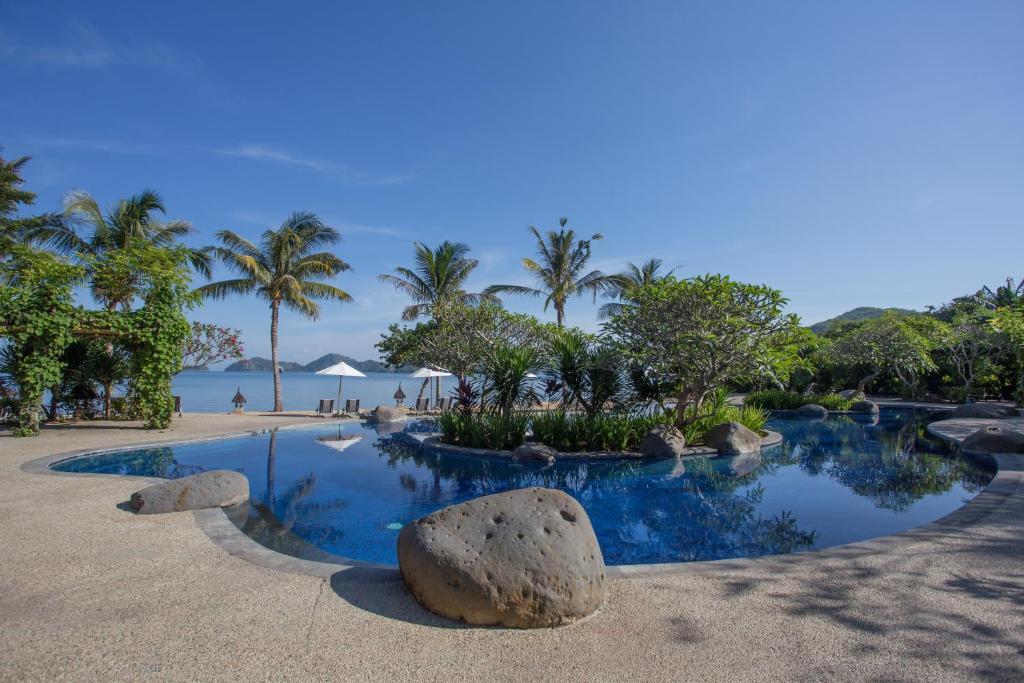 a resort swimming pool with a rock in the middle at Bintang Flores Hotel in Labuan Bajo