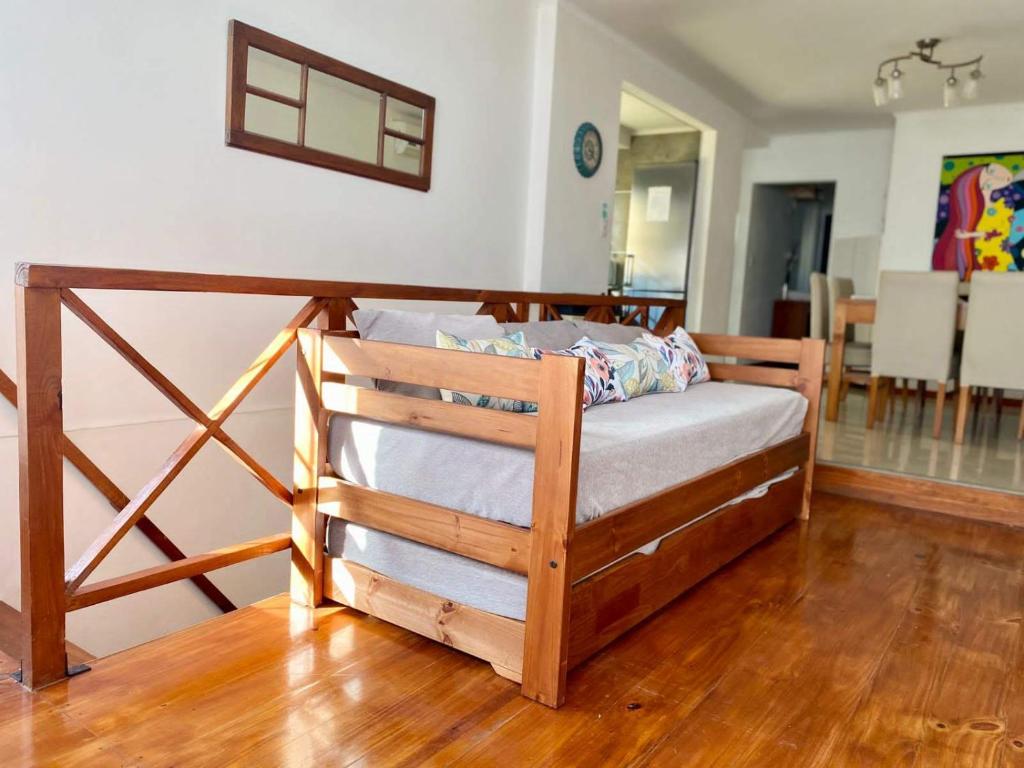 Cama de madera en habitación con suelo de madera en Apart Colon en Rufino