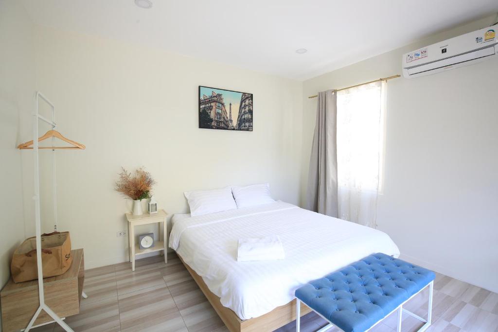 um quarto com uma cama branca e um banco azul em Day Off House Chiang Mai Near Walking Street em Chiang Mai