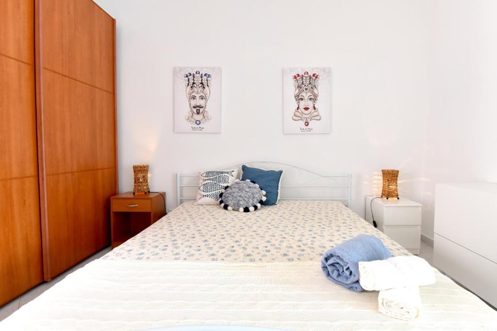 een slaapkamer met een bed en twee foto's aan de muur bij ONDA MARINA in Agrigento