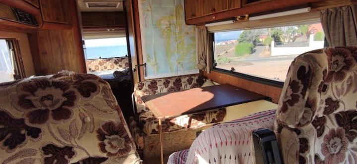 a train room with chairs and a table and a window at Van with 3 double bed, nice and quite place, to 500m beatufill beach in Adeje