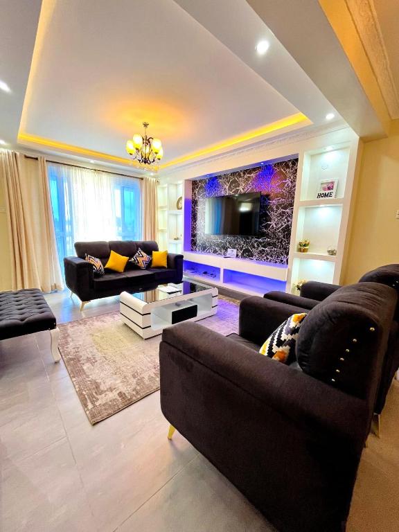 a living room with two couches and a tv at Nitro Homes Nyali in Mombasa