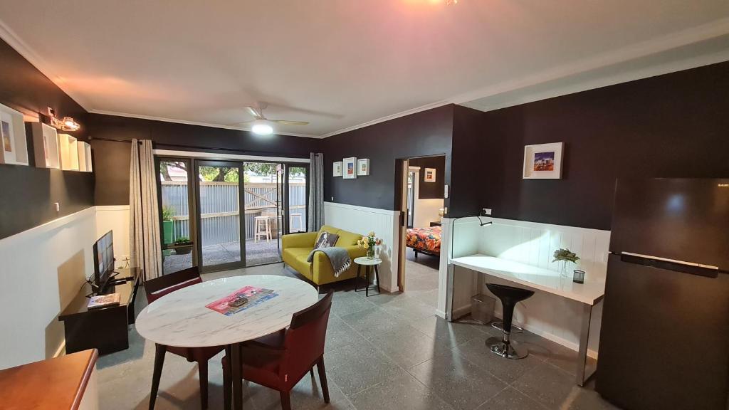 a living room with a table and a kitchen at The Settler, Port Pirie in Port Pirie