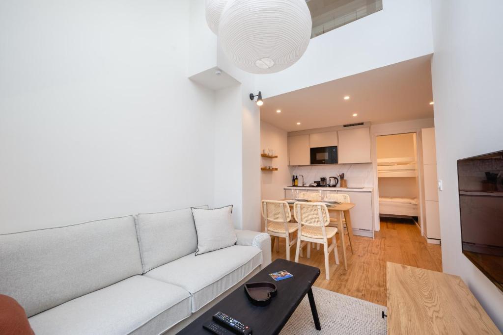 un salon avec un canapé blanc et une table dans l'établissement Le Duplex Vaugelas atypique en plein Centre Ville, à Annecy