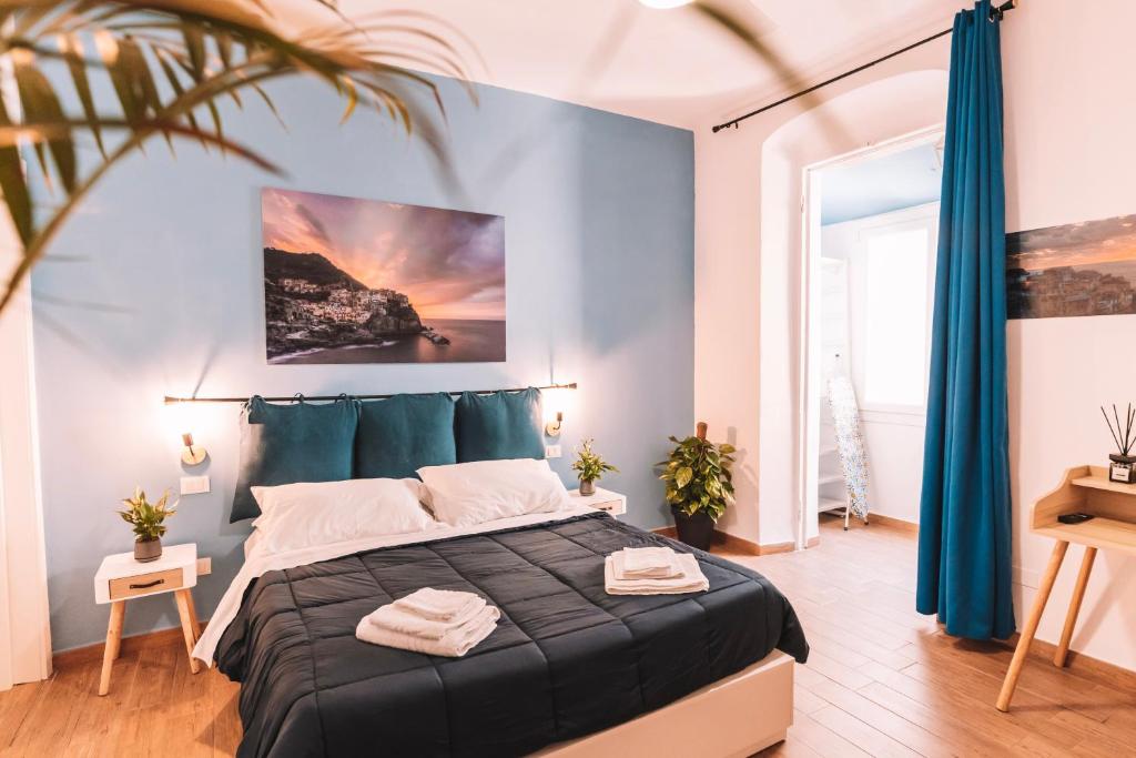 una camera da letto con un grande letto con pareti blu di charmelisè a La Spezia