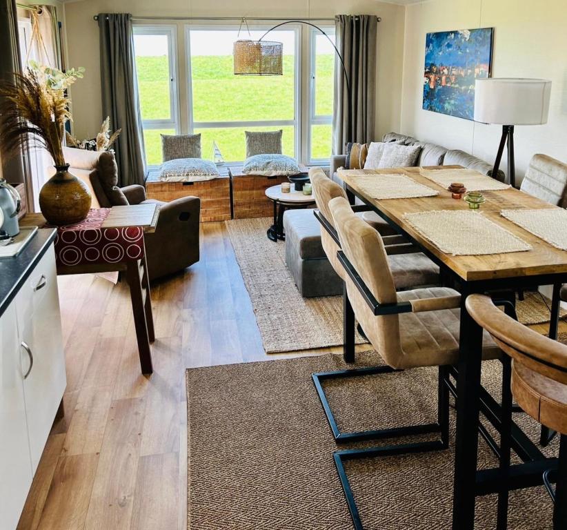 a living room with a table and a couch at Traumlage Meerblick Nr 26 Ferienhaus "Schau aufs Meer" erste Reihe unendliche Weite, eingebettet in der Natur in Westerland