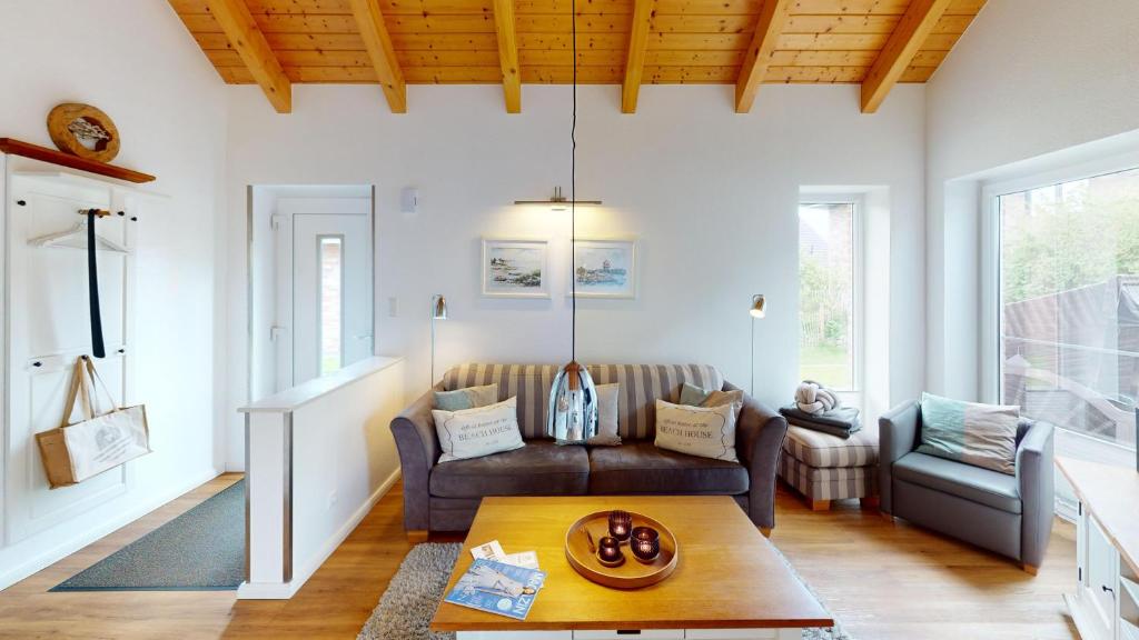 - un salon avec un canapé et une table dans l'établissement Feriendorf Südstrand Haus 36, à Pelzerhaken