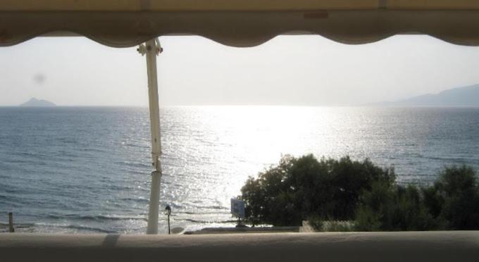 a view of the ocean from a table with an umbrella at Crysalis Studios in Kalamaki