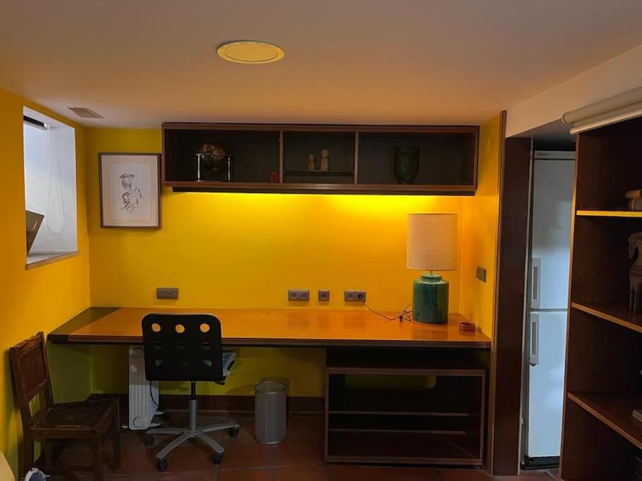 een bureau in een kamer met een gele muur bij Cozy Duplex Príncipe Real in Lissabon