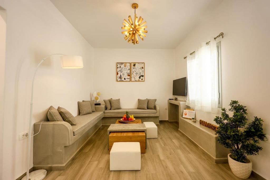 a living room with a couch and a table at Villa nectar 2 bedrooms 4 pers with Jacuzzi by MPS in Perivolos