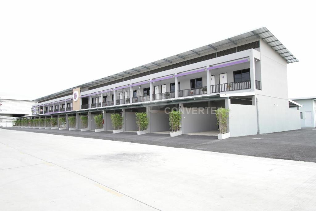 a large white building with balconies on it at Eazy Motel B.a.n.g.n.a in Samutprakarn