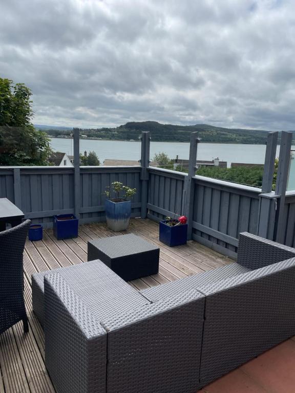 a patio with a table and chairs on a deck at Tigh mo Ghraidh ( House of my love) in Inverness
