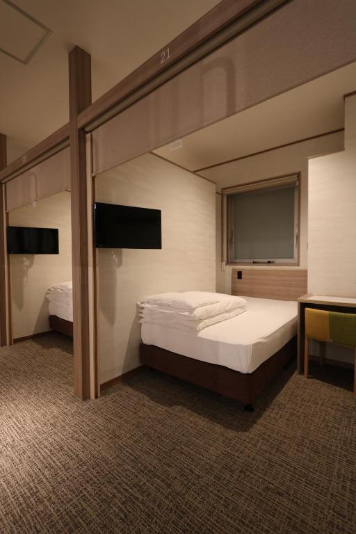 Postel nebo postele na pokoji v ubytování Cabin & Capsule Hotel J-SHIP Osaka Namba