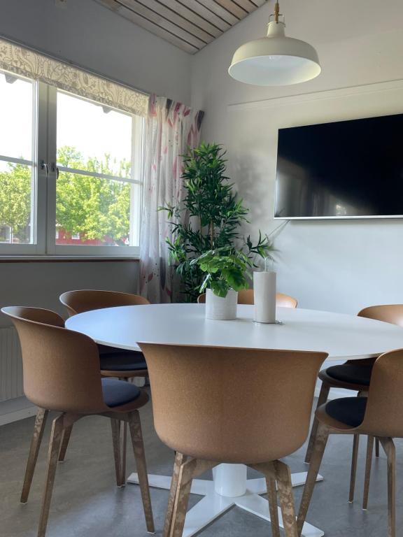 uma sala de jantar com uma mesa branca e cadeiras em Valla Folkhögskola em Linköping