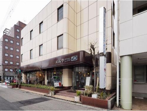 ein Gebäude in einer Stadtstraße mit einem Geschäft in der Unterkunft Hotel Terminal Inn in Niigata