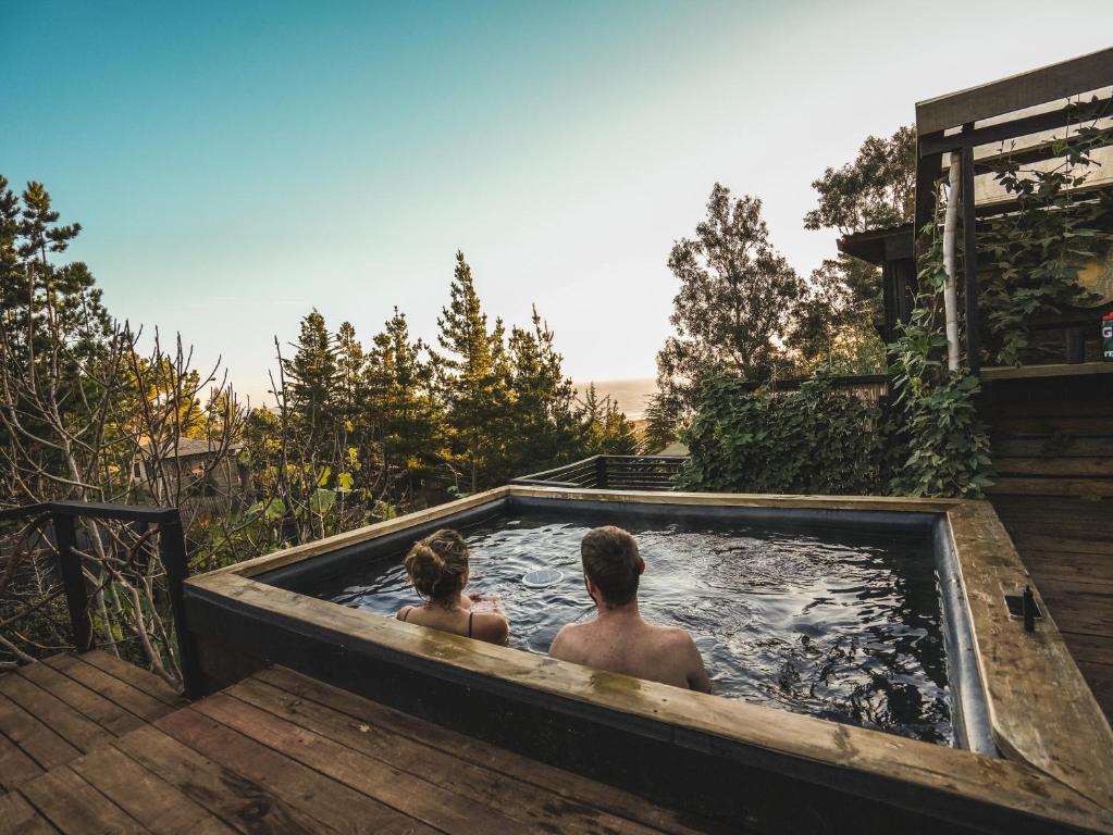 a man and woman sitting in a hot tub at Punta Ballena Lodge in Pichilemu