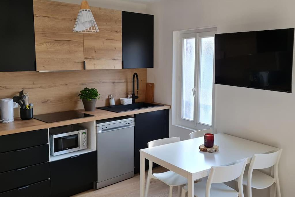 a kitchen with a table and a white table and chairs at Luxury at Barbizon in Barbizon